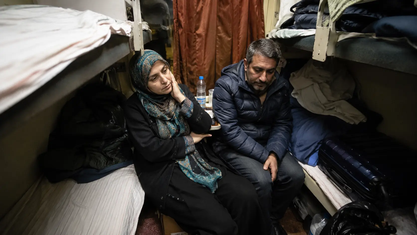 10 Worst Train Journeys You Must Avoid Globally 5 Worst train journeys 2026 — couple in a cramped sleeper compartment unable to rest overnight