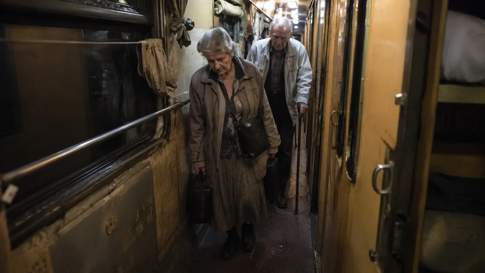 10 Worst Train Journeys You Must Avoid Globally 9 Worst train journeys 2026 — elderly passengers navigating a narrow night train corridor with luggage